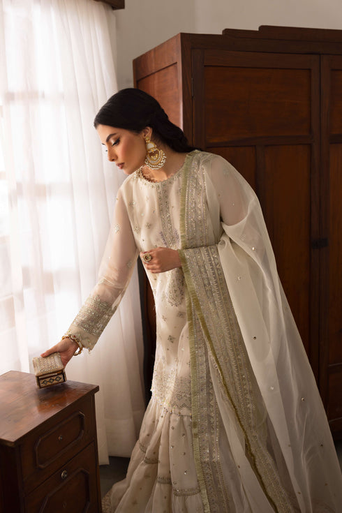 Side view of NAQSHI Jeena showcasing straight-cut organza shirt silhouette, floral embroidery continuing to side and full sweeping dupatta.